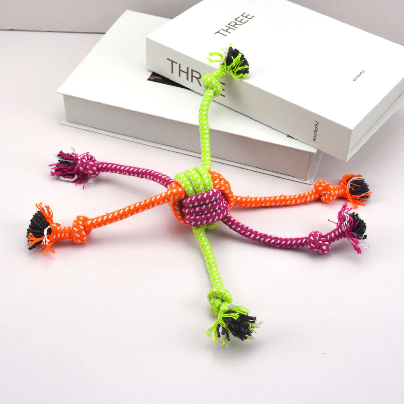 Colorful rope knot toy for dogs by Pawzena Palace featuring durable braided cotton for chewing and tugging fun.